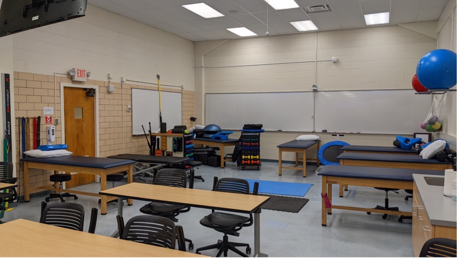 Athletic training program lab with exercise tables, weights, yoga balls, and exercise equipment