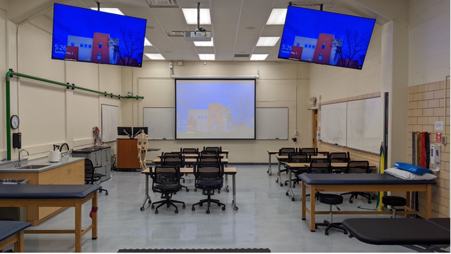 Athletic training program lab room with desks, tvs, and white boards