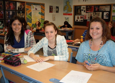 Kaitlyn Jaramillo (l.) and Michelle Radosevich (r.) review a lesson with an Austrian student.