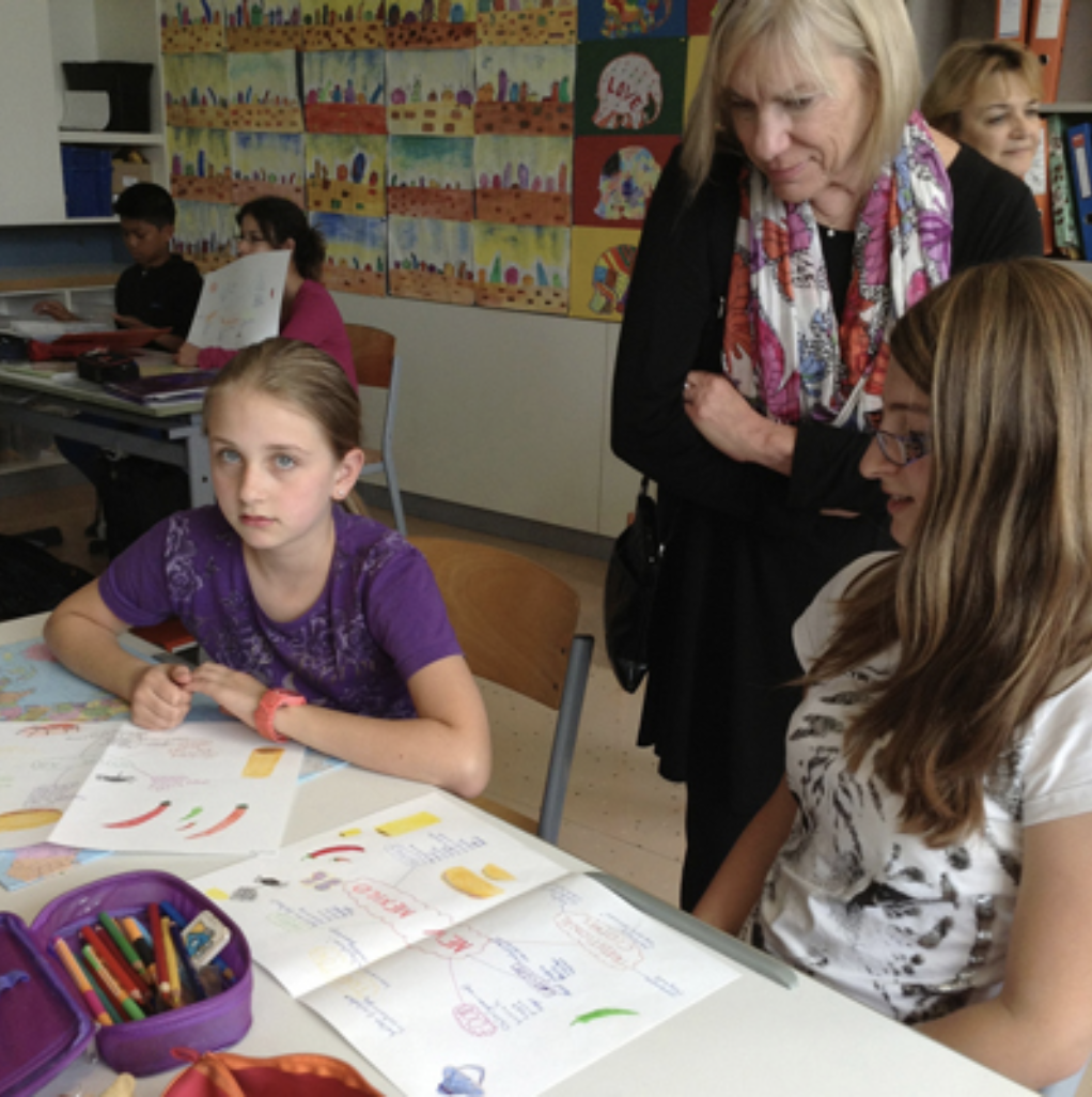 photo of Deborah Rifenbary with several young female students sitting at desks