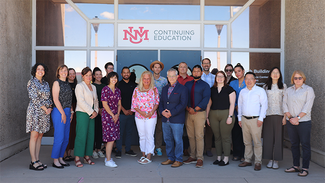 photo of 19 new COEHS faculty standing in front of a building