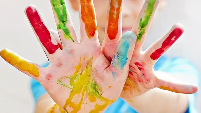photo of child's hands covered in finger paints