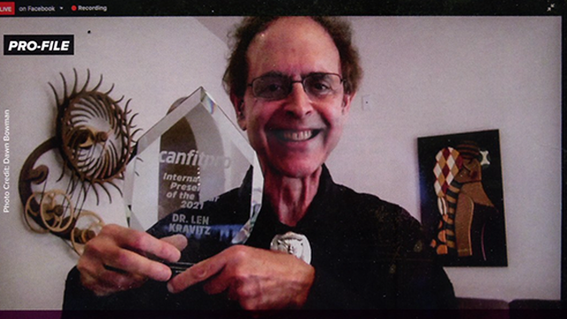 photo of Dr. Len Kravitz holding up an award presented over video conference